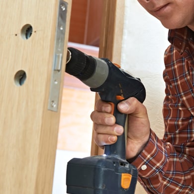 Handyman installing a lock on a door